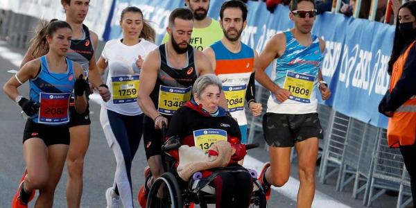 Eric domingo con su madre en silla de ruedas durante de maratón.