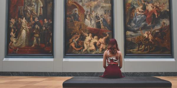 Mujer observando cuadros en un museo